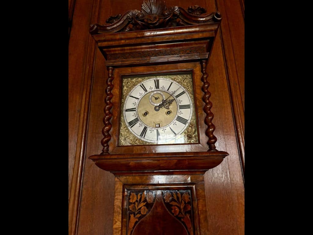 Close up photo of the ornate clock face of the Daniel Quare clock