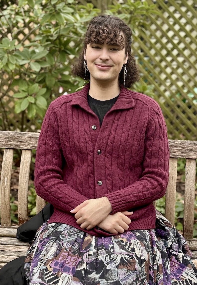 Photo of student sitting on a wooden bench