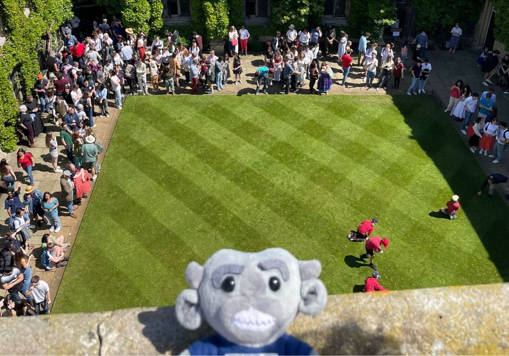 Photo of the Imp on the tower overlooking Front Quad with children collecting pennies below