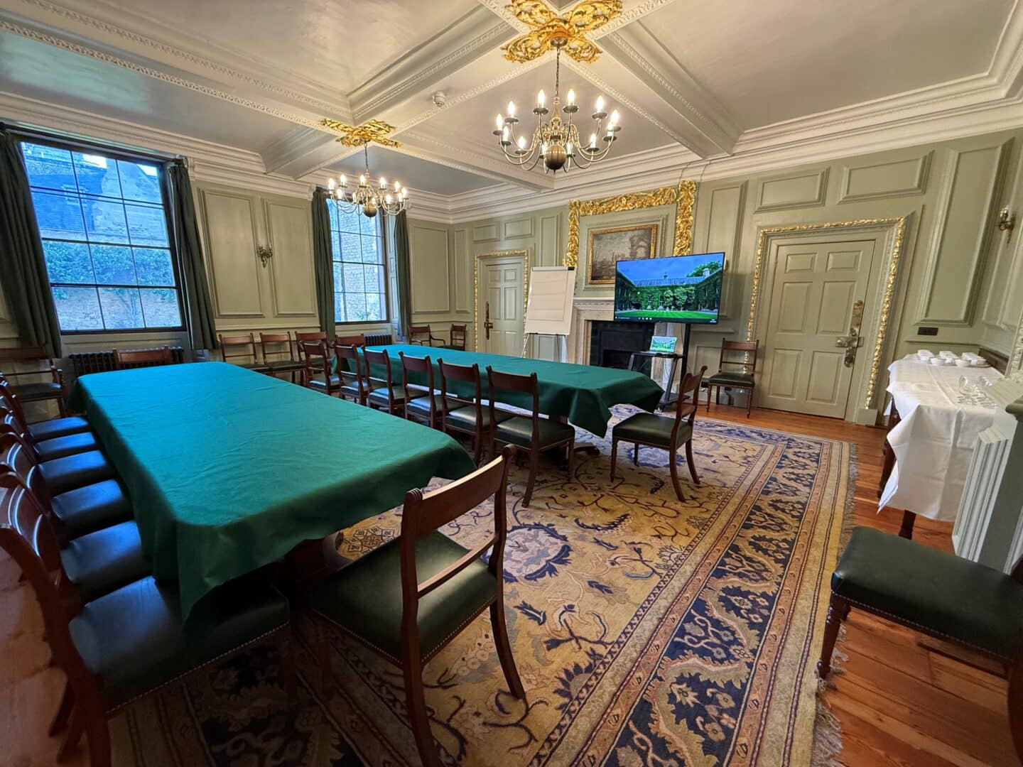 Photograph of the Beckington Room with two long tables, several chairs, and a large screen at the front