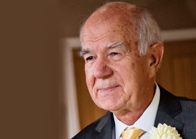 Photo of Bojan Bujić wearing a formal suit and white flower in his lapel