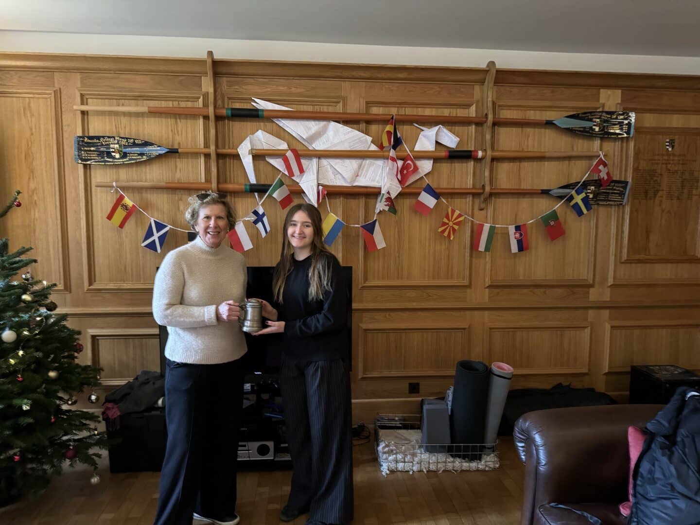 Photo of Charlotte Paylor and Sue holding the LCBC tankard in the MCR