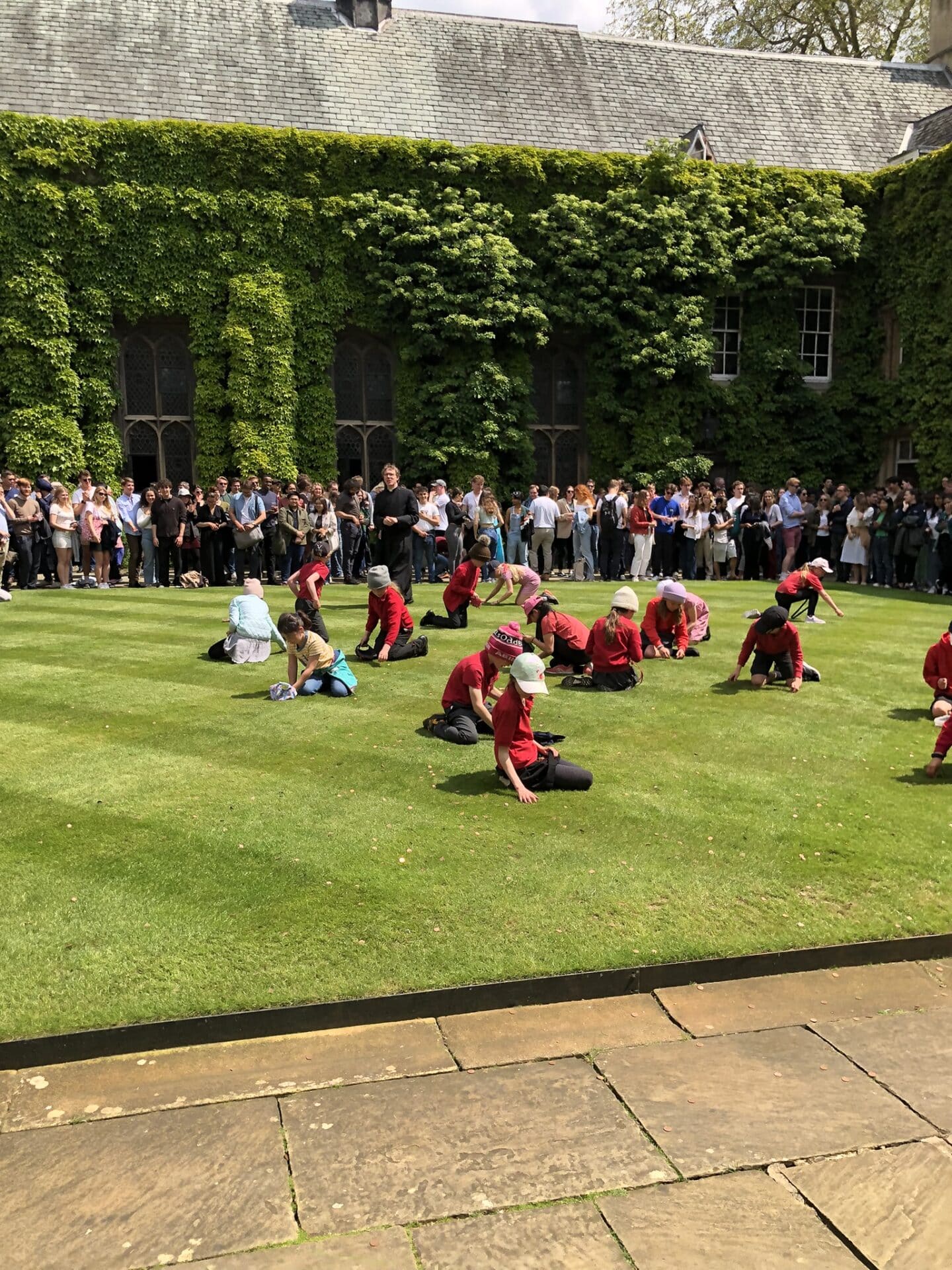 Primary school children gather pennies in Front Quad for Ascension Day 2023