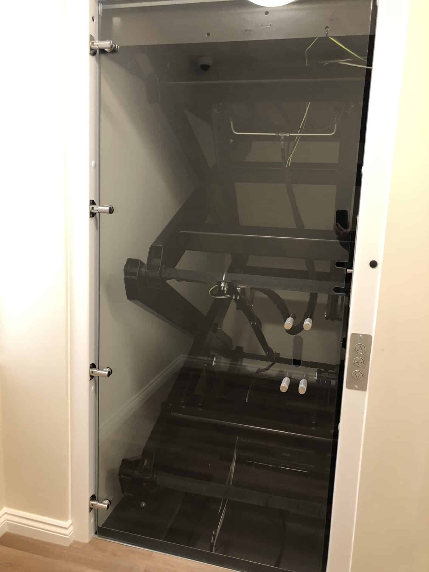 Photo of Library lift shaft with metal mechanism behind protective glass