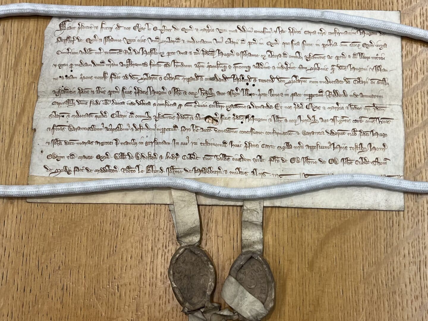 13th-century manuscript on parchment, dated c.1275, recording a gift of property near All Saints parish—mentioning a well now located in Lincoln College’s Fellow’s Garden. Two pendant wax seals attached at the bottom.