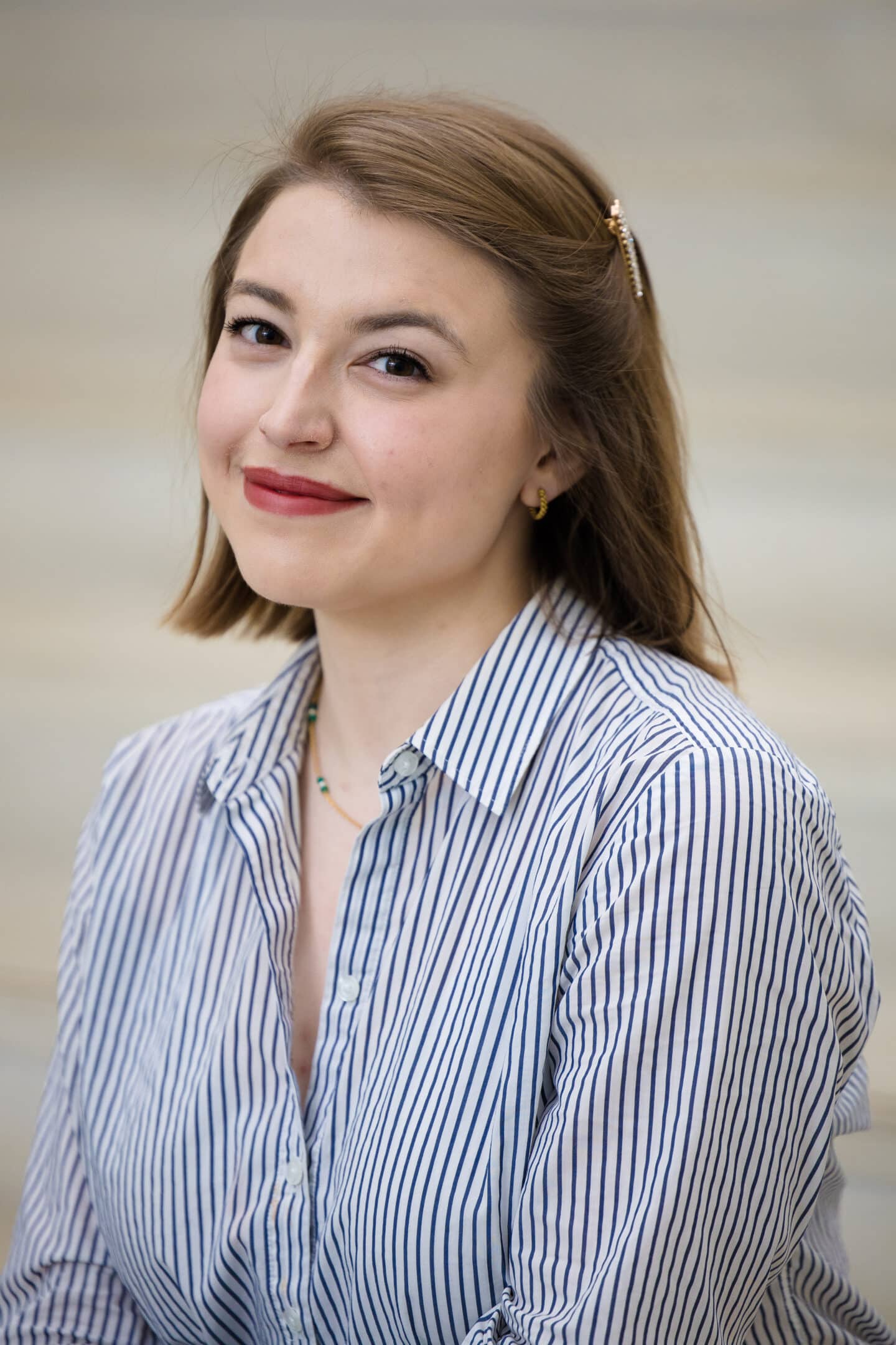 Photo of Isabella Turilli wearing a blue and white striped button down shirt.