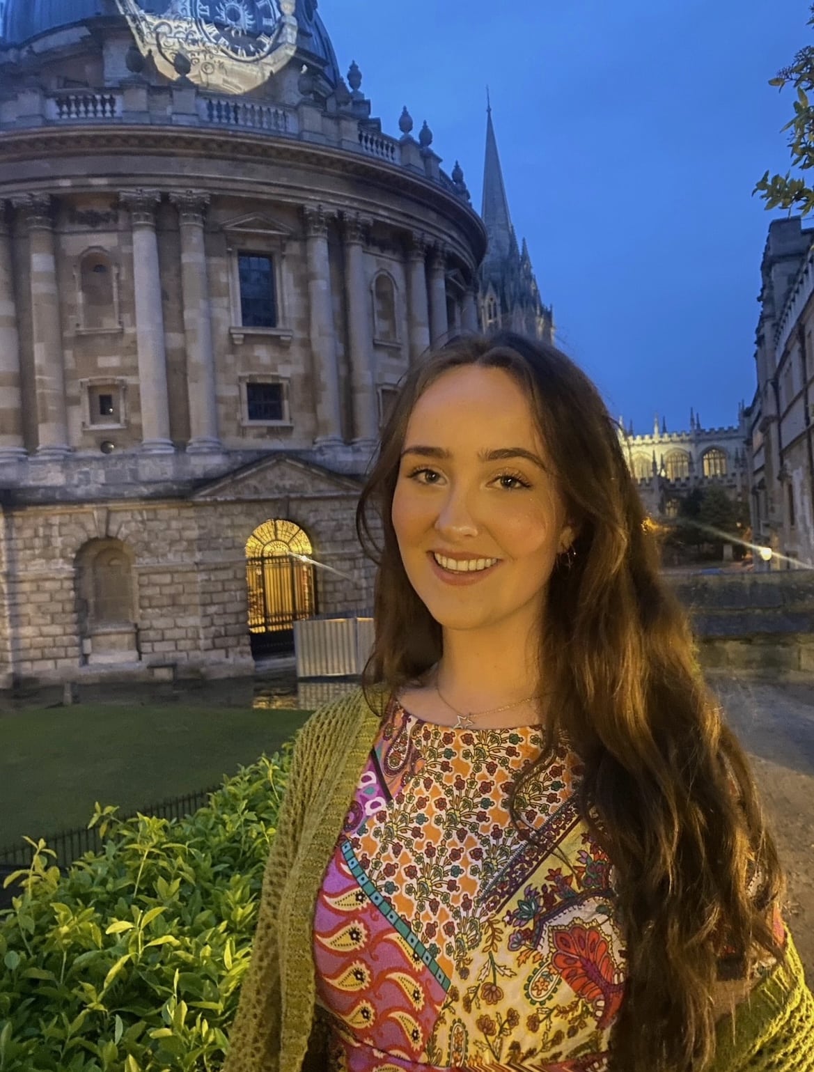 Photo of Manon Hammond wearing colourful top in front of Bodleian