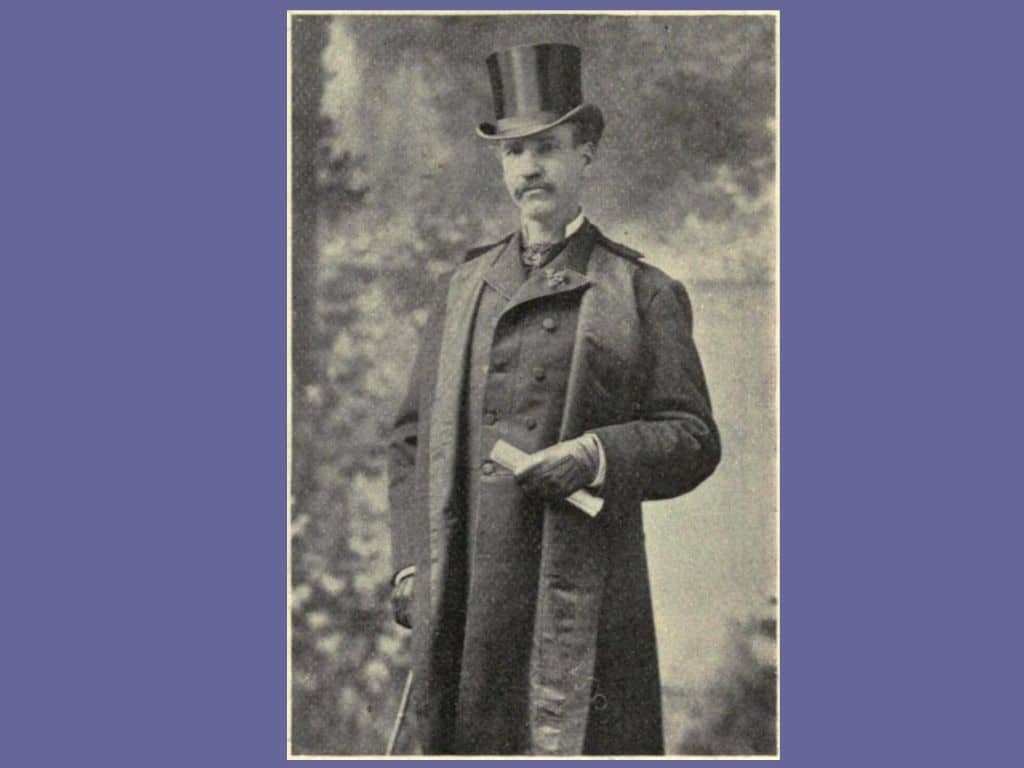 Black and white photo of Robert Duncan Milne in tophat and long coat