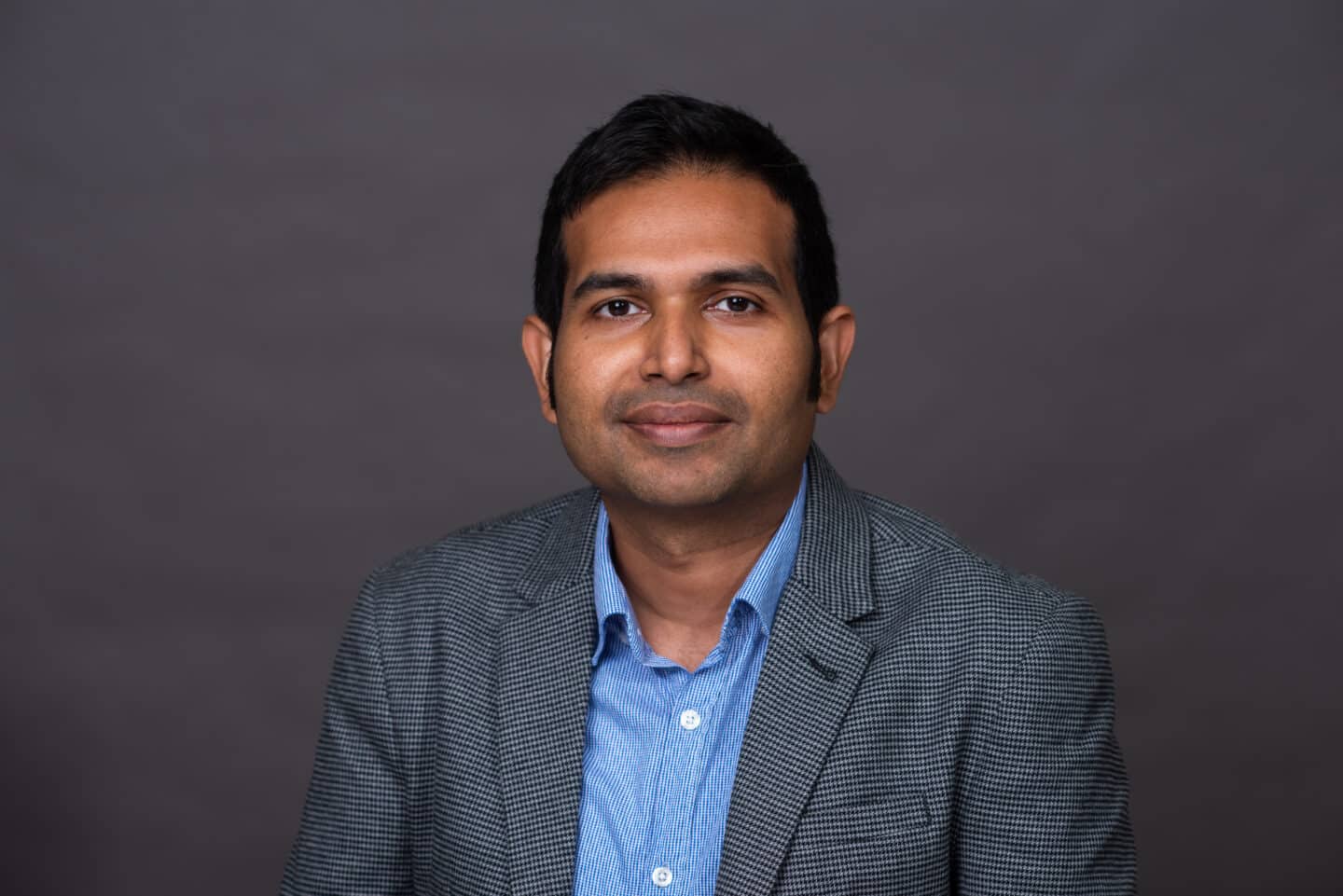 Headshot of Dr Nafiz Chowdhury, a man in a grey suit and blue shirt