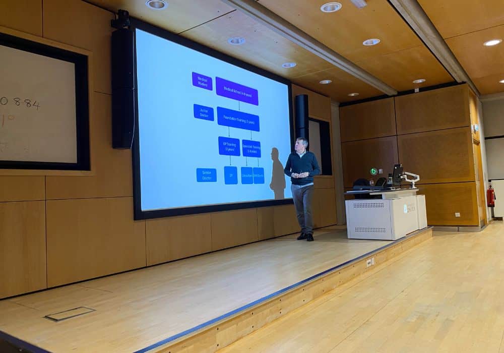 Lecturer looking at a large presentation screen in a lecture hall