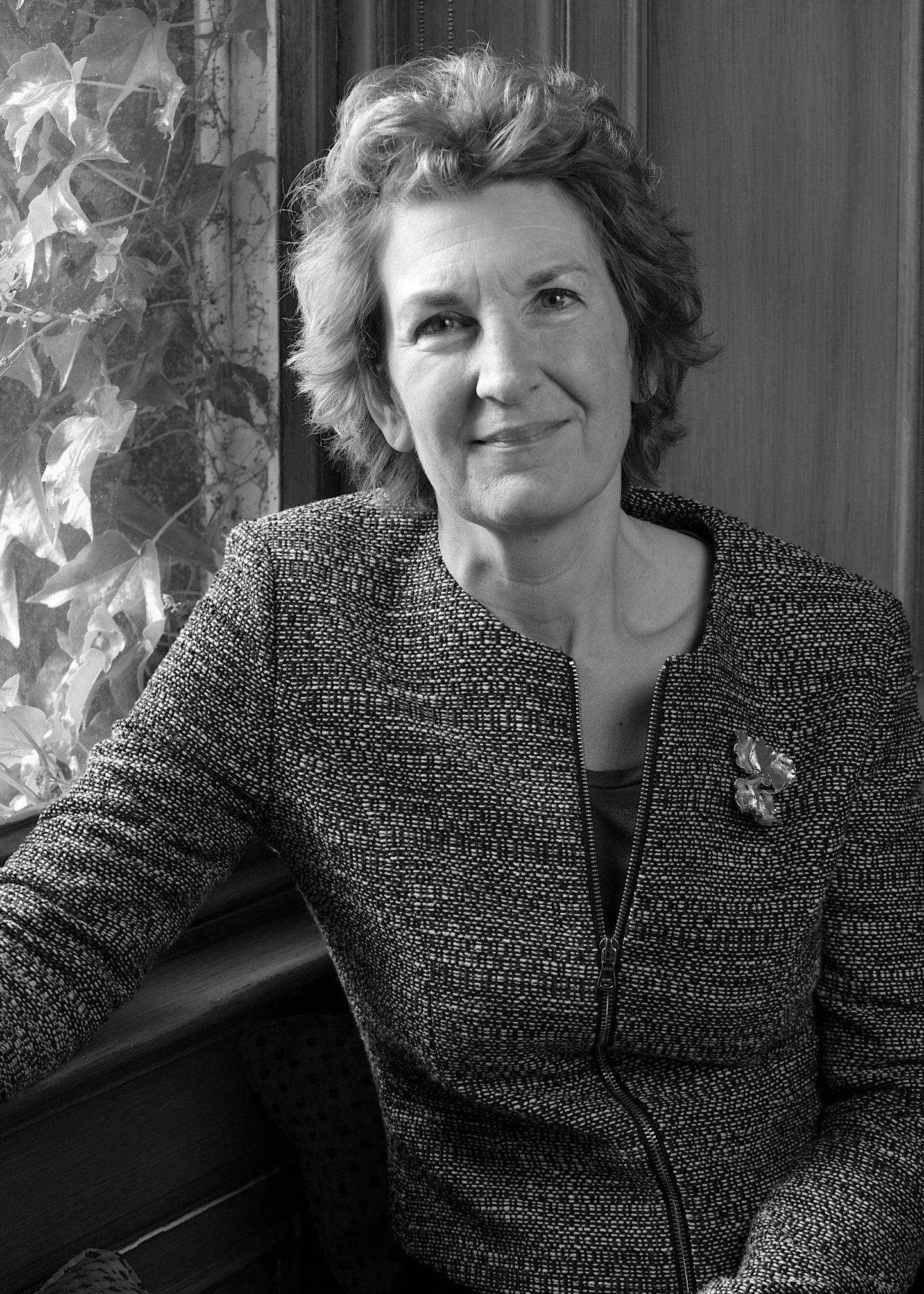 Greyscale photograph of Alison Hartley, a woman in a zipped up top
