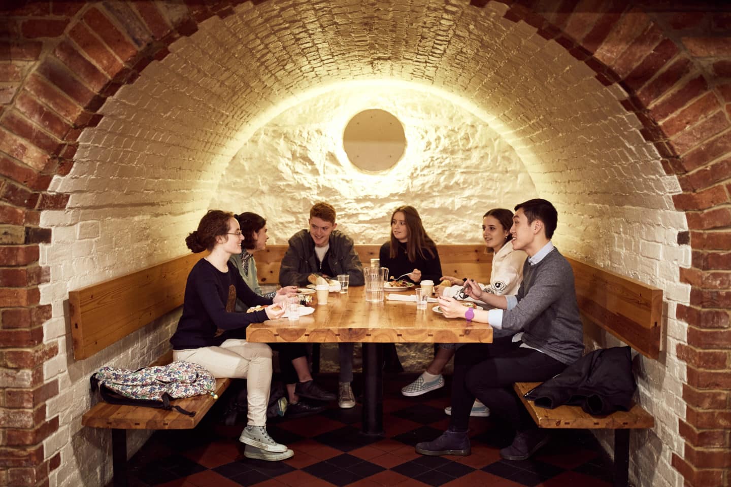Students sitting around a table eating in the Lincoln College Bar