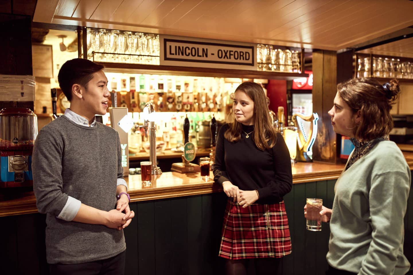 Three students talking by the Lincoln College Bar