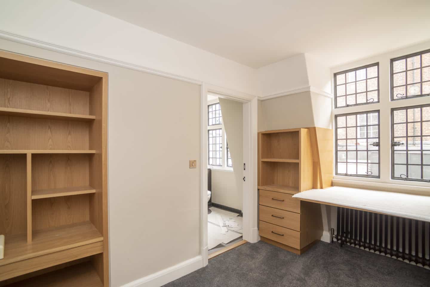 Room with a wardrobe and shelves, and a desk in the process of being built
