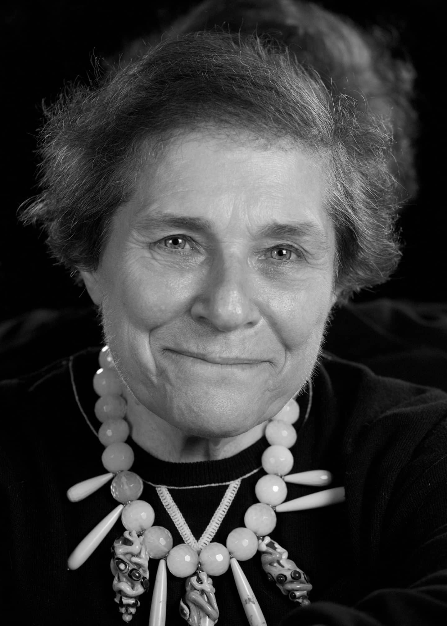 Greyscale photograph of Judith Weingarten, a woman wearing a large beaded necklace