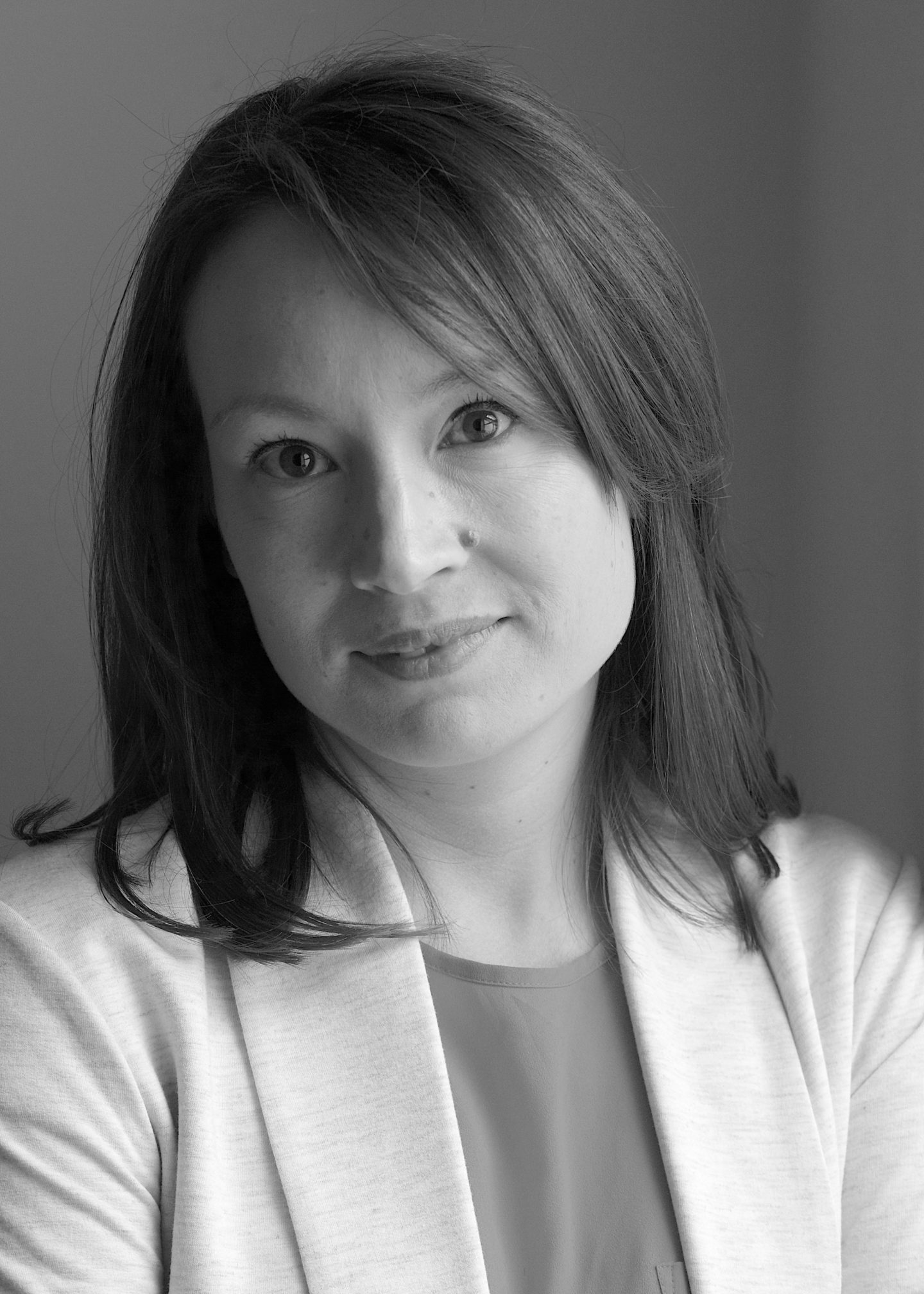 Greyscale photograph of Laura Brown, a woman wearing a top and jacket