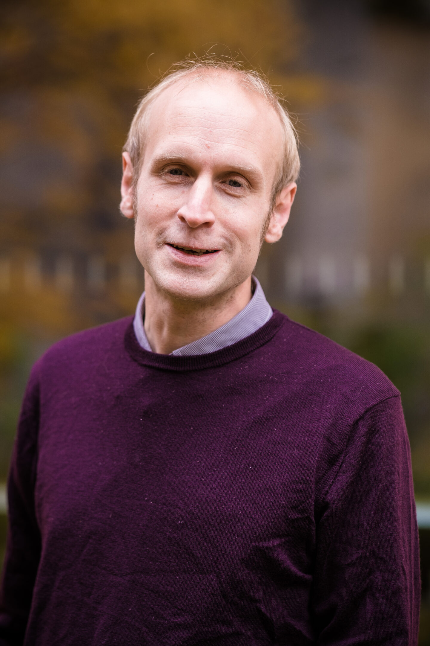 Headshot of Mark Roberts, a man in a purple sweater