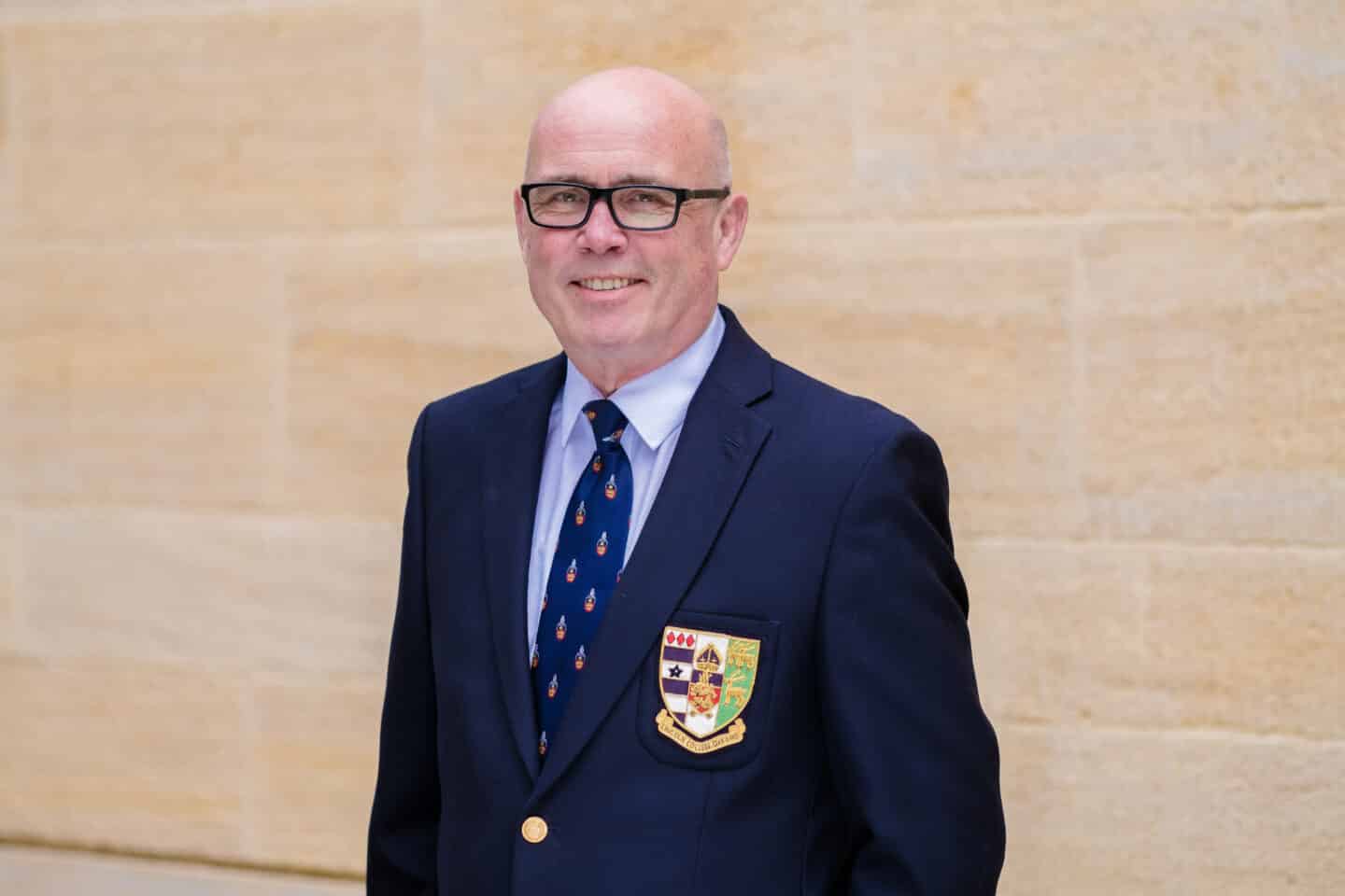 Image of Peter van de Kerkhof, a man in glasses and a Lincoln College branded porter's suit