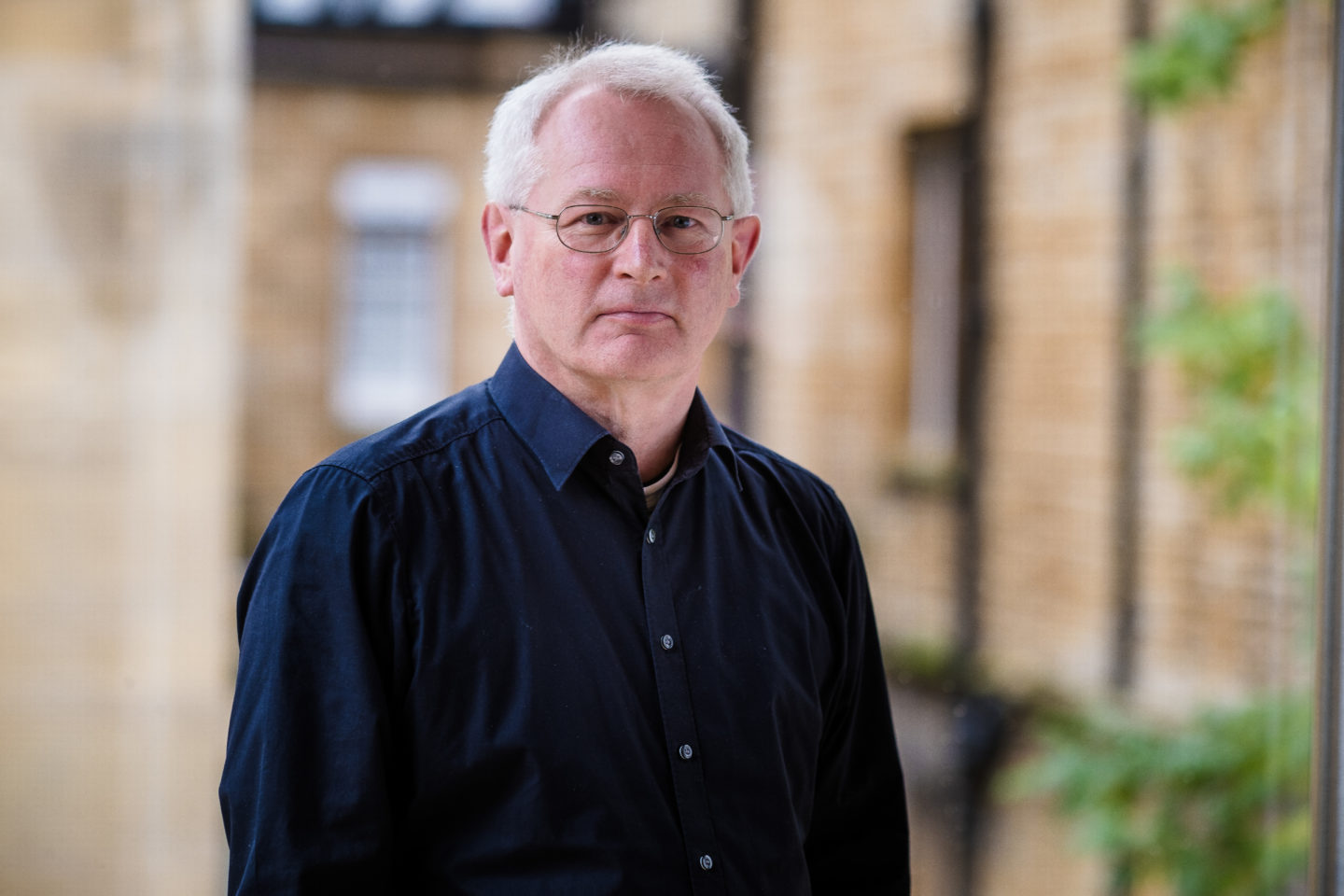 Headshot of Richard Little, a man in glasses and a dark blue shirt