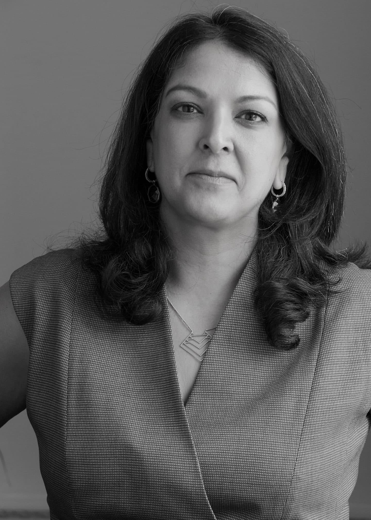 Greyscale photograph of Sonali Naik, a woman with earrings and a necklace