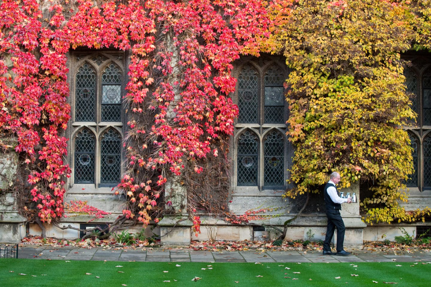 The Butler walks through an autumnal Front Quad