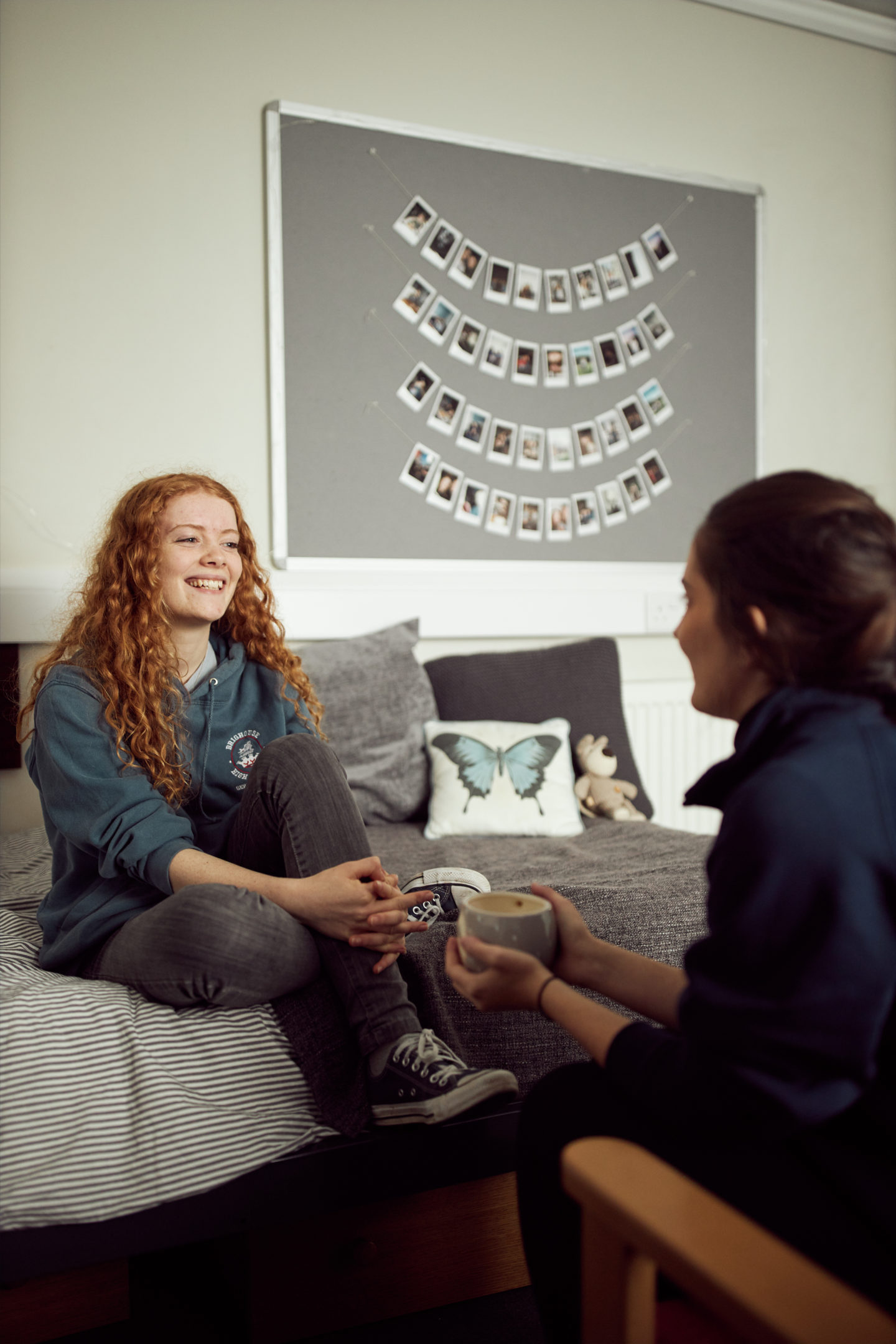 Two students sitting and talking in a bedroom