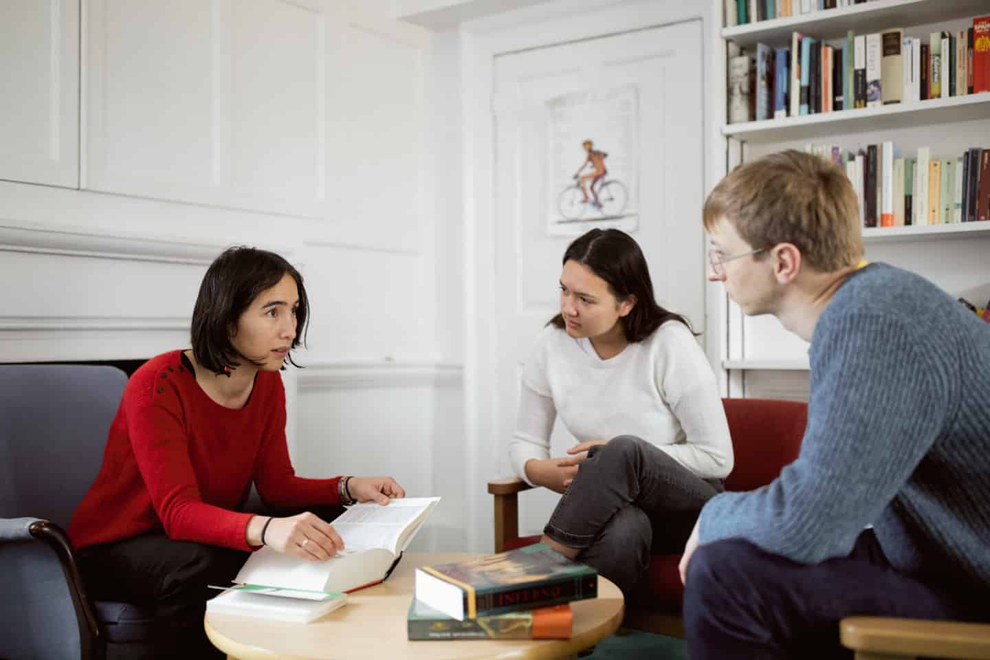 Students and their tutor sitting in an office with books