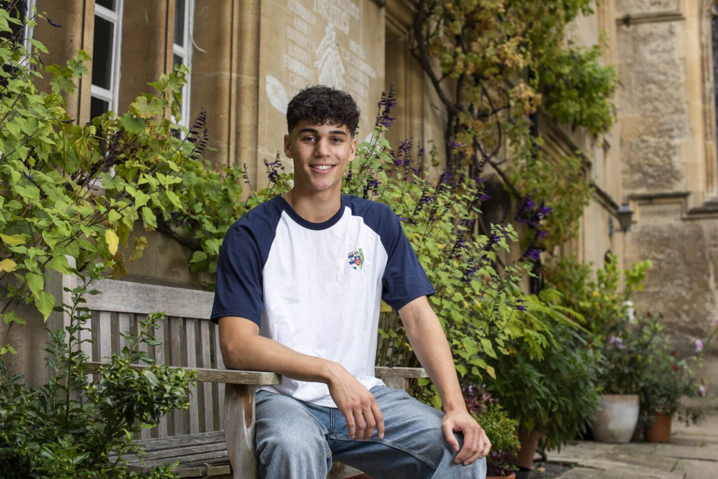 Photograph of a student in a Lincoln College t-shirt seated in Grove Quad