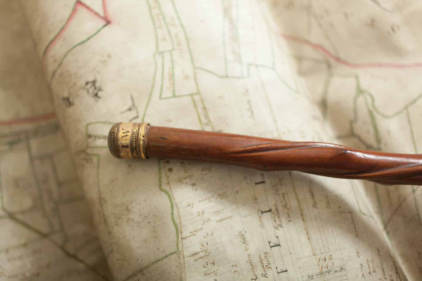 Ornate gold bottom of a wooden walking stick